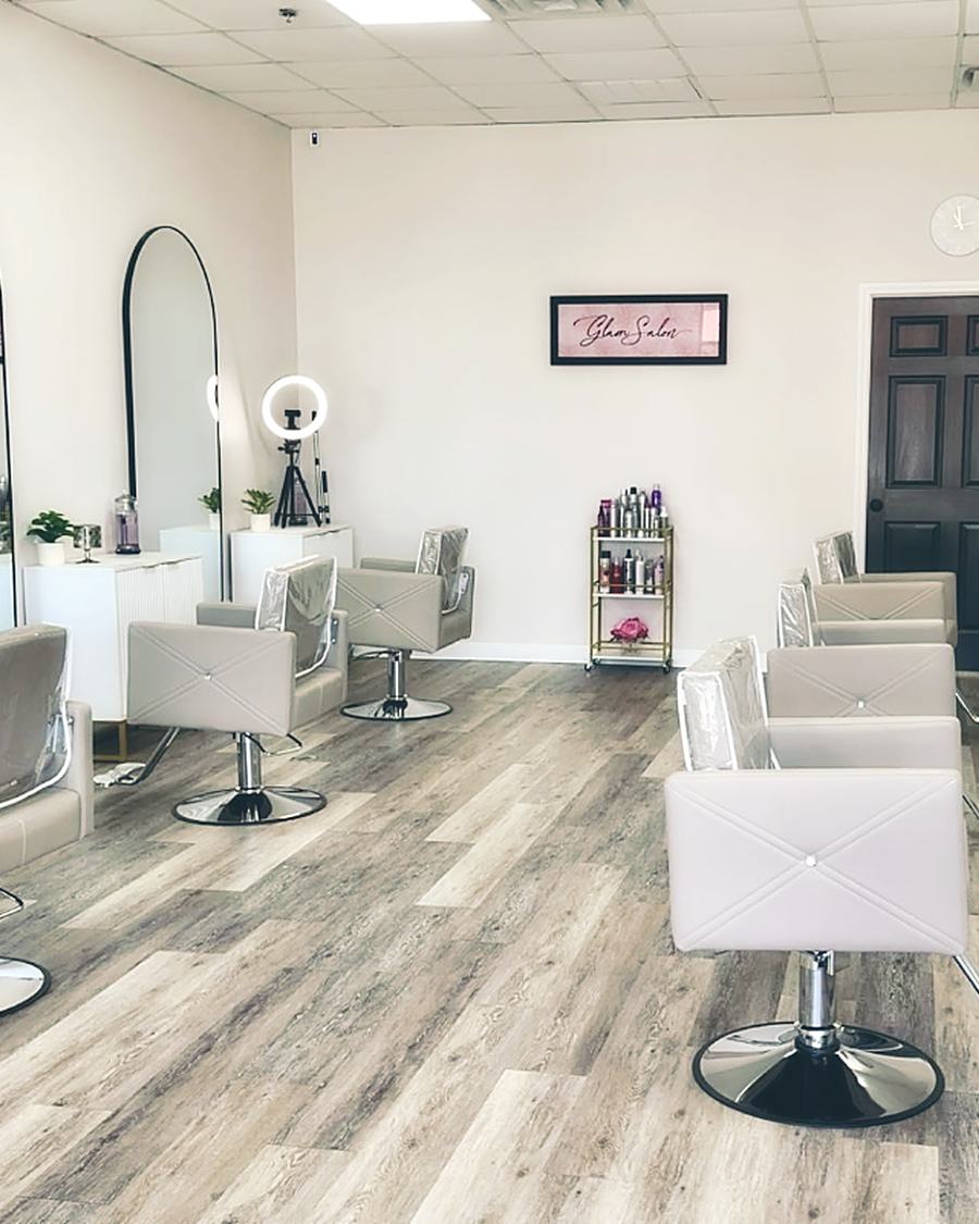 The salon floor with white stations, arched mirrors and blush chairs