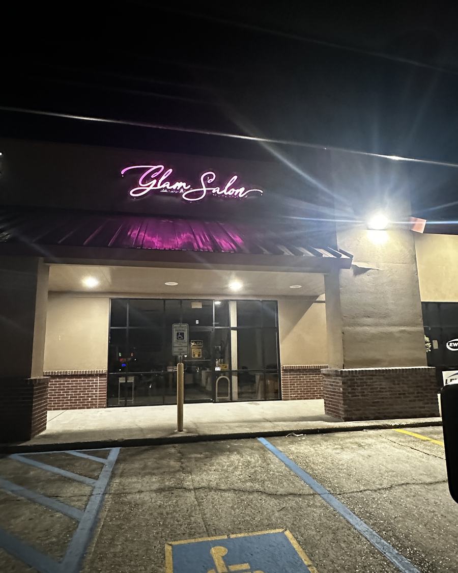 Our storefront at night with the pink neon sign